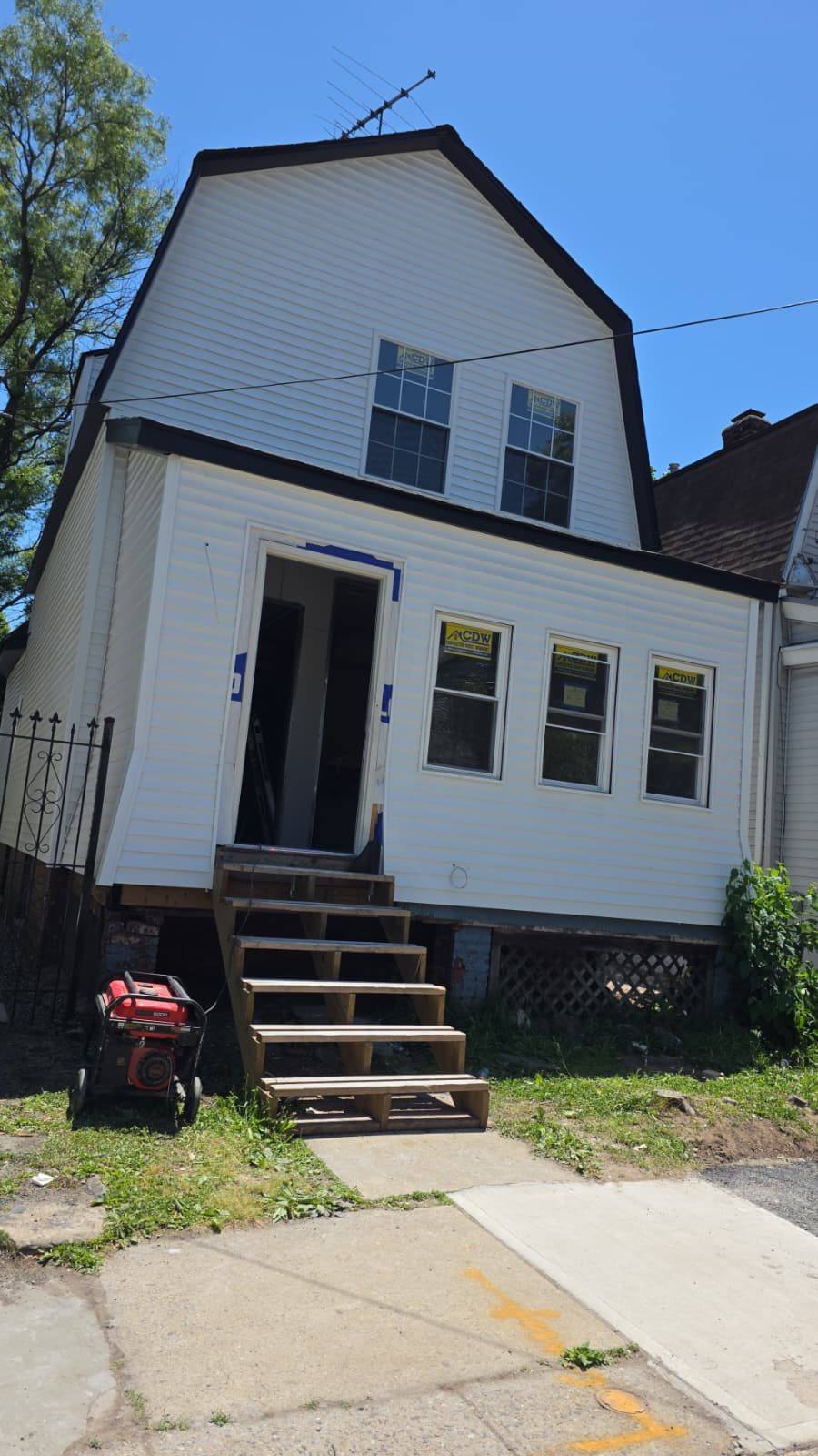 Home mid-renovation with new siding and window installation in progress